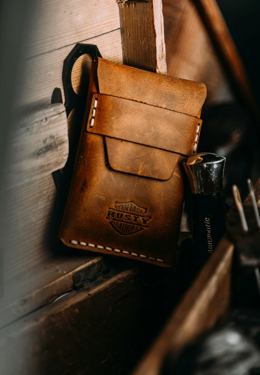 a leather wallet sitting next to a bottle of whiskey