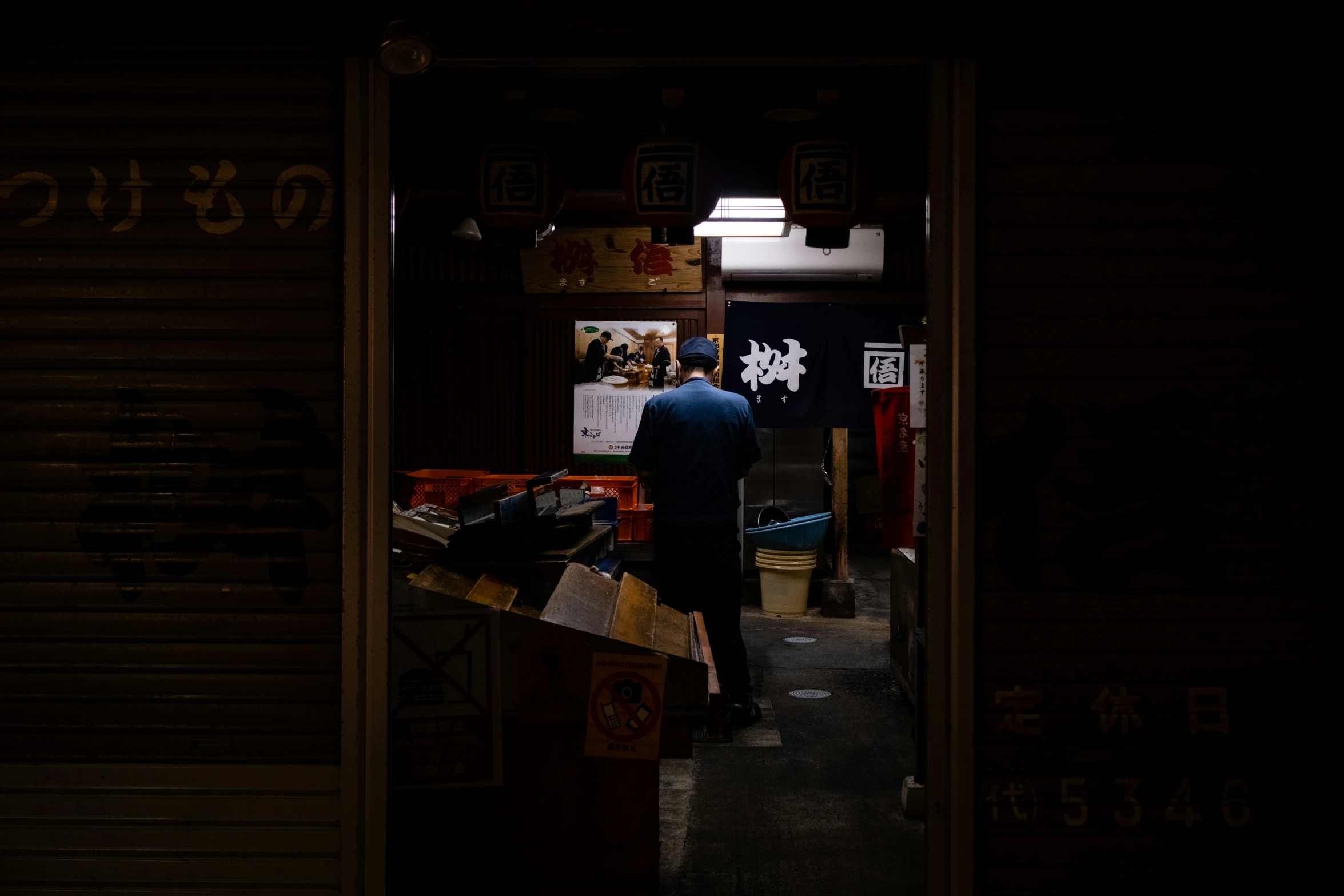 a person in blue standing at a street corner with many boxes