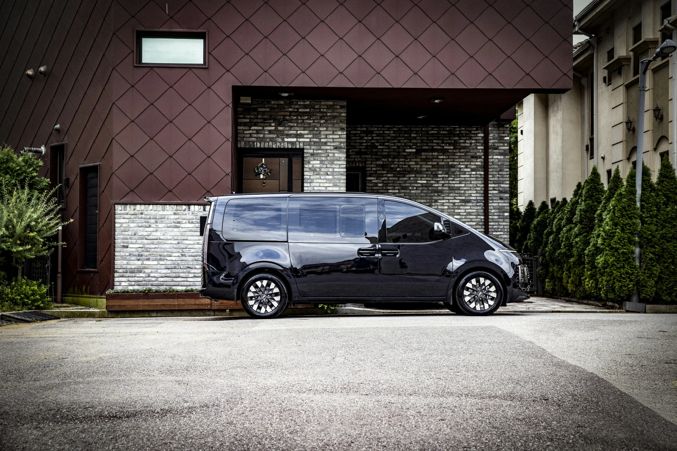 the small black van is parked in front of the house