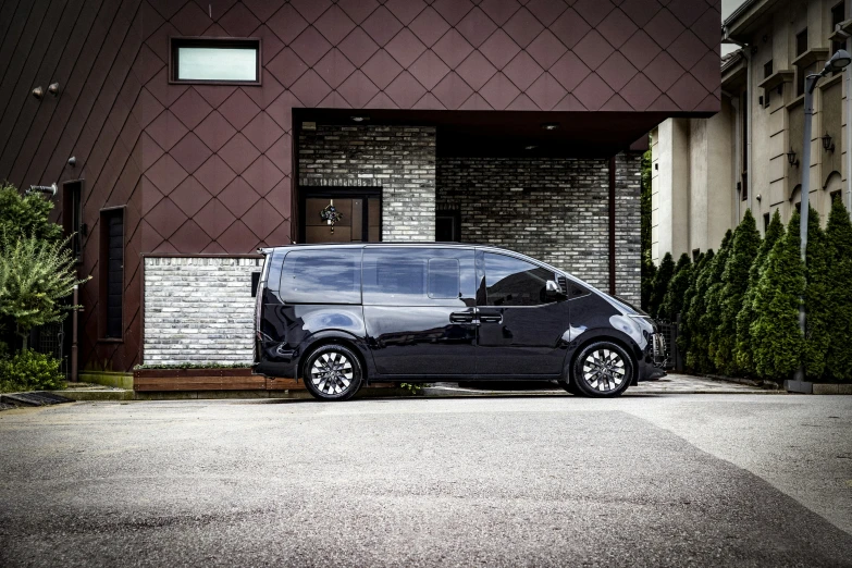 the small black van is parked in front of the house