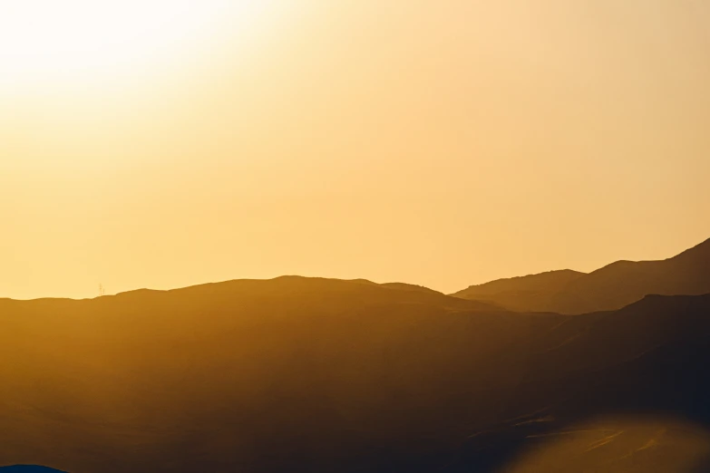 the sun is setting behind a large mountain