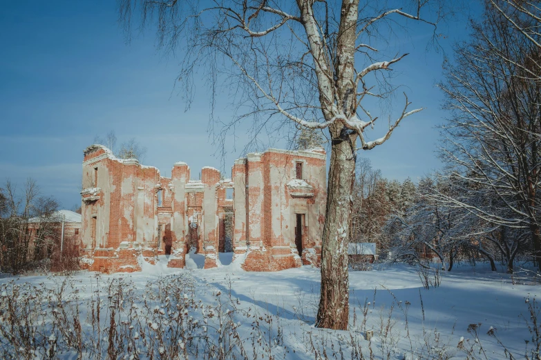 a brick building surrounded by snow and trees