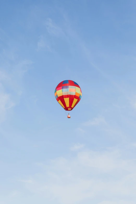 there is a multi - colored  air balloon flying in the sky