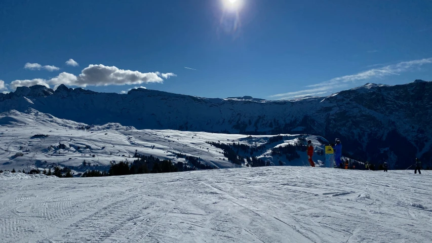 a group of people in skis on top of a snow covered hill