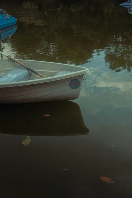 a small row boat tied to a dock next to a lake