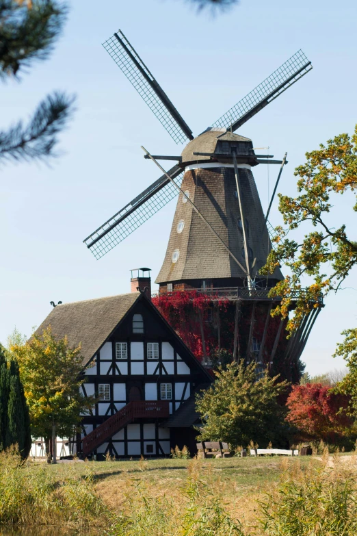 an old windmill is shown near a house