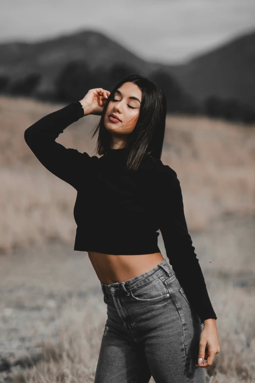 a woman standing in a field posing for the camera