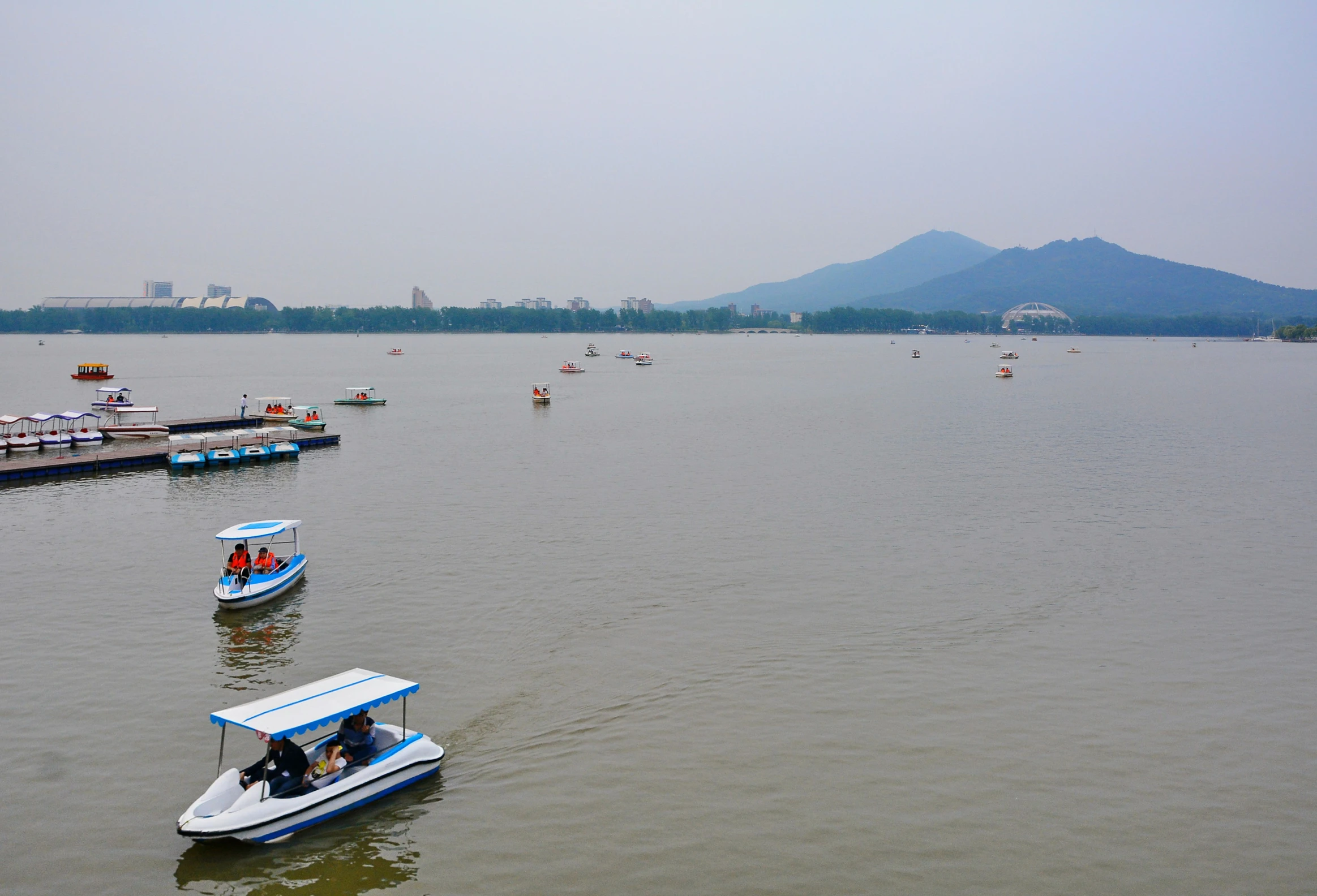 several boats in the water and people sitting on the back