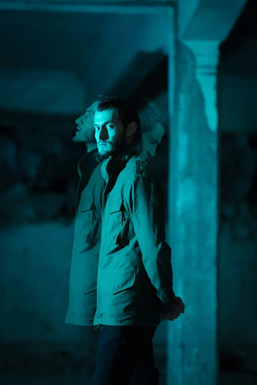 man standing in dark room holding back his jacket