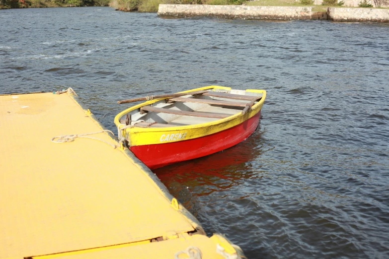 a small boat tied to the dock near water