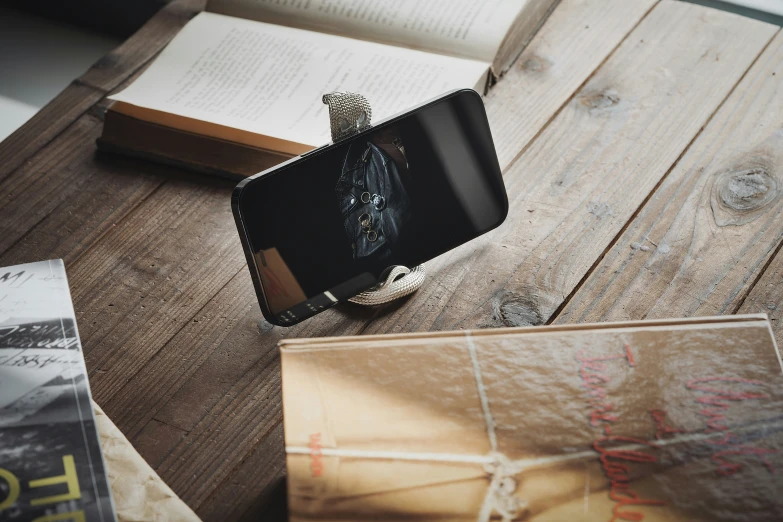 a book sitting on top of a wooden table next to a cellphone