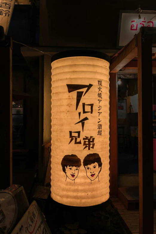 a lighted oriental lantern depicting two men and a girl with their hair pulled back