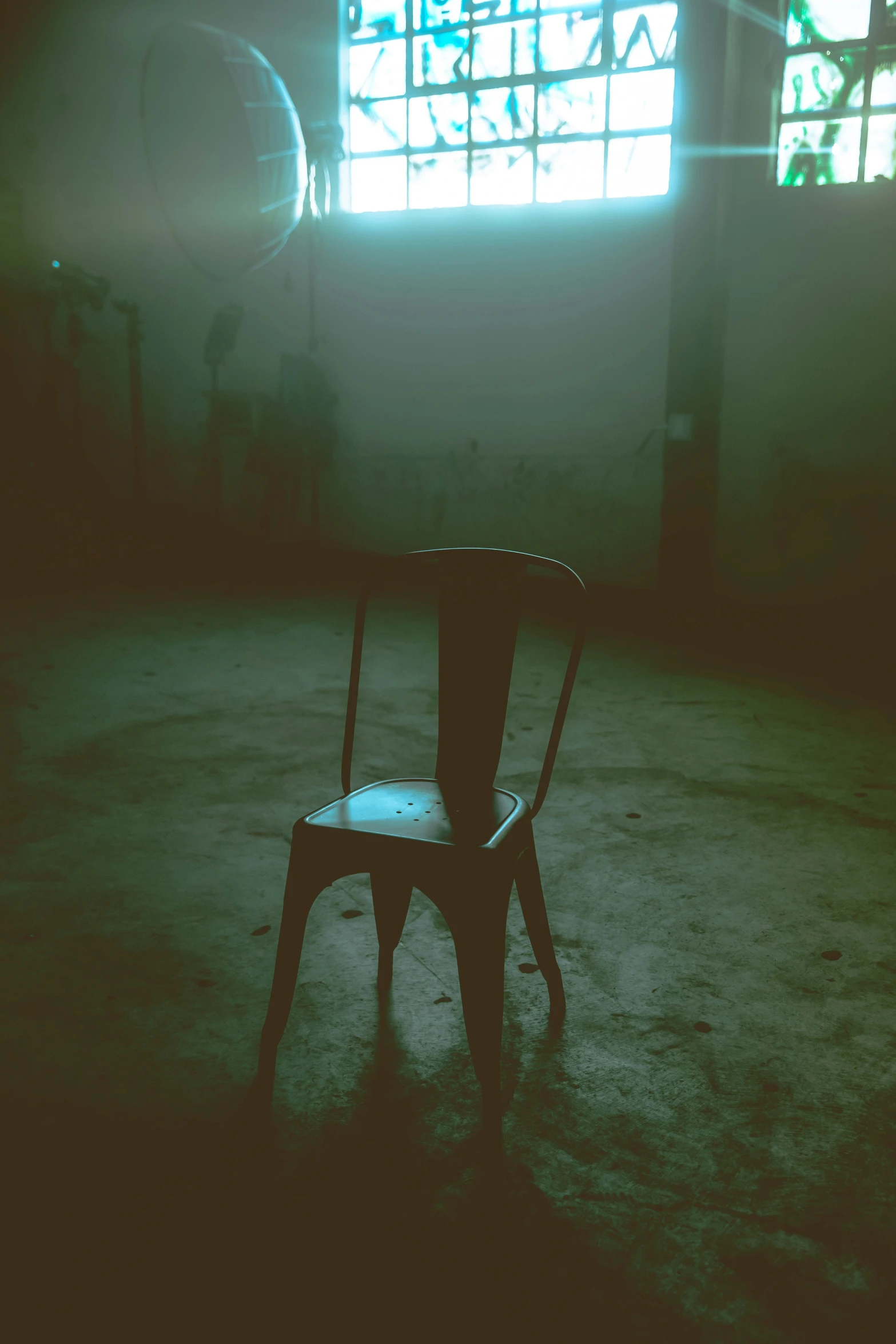 the back of an empty chair with the light coming from a window