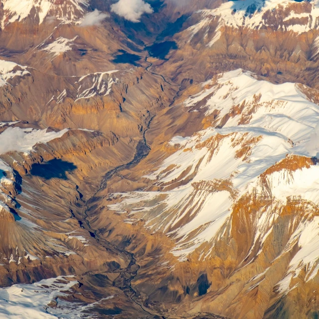 snow covered mountains and rivers, viewed from an airplane
