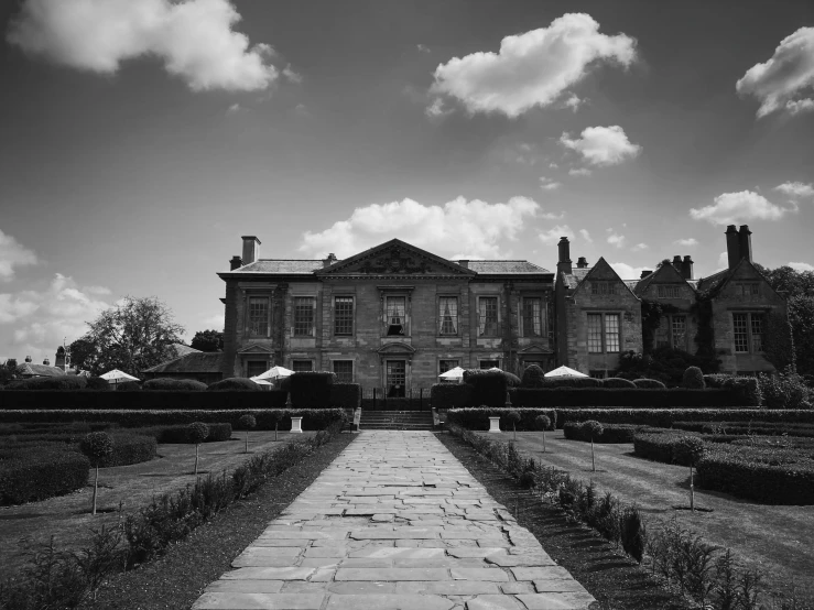 a brick walkway in front of a large house