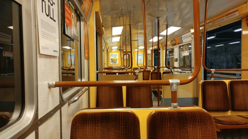 empty seat inside subway train with yellow railing