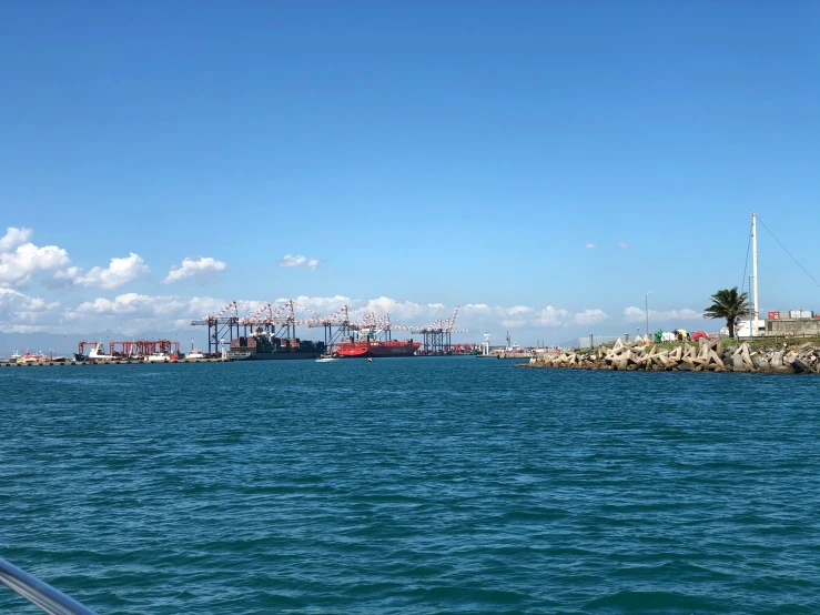 blue water with cranes in the distance on a sunny day