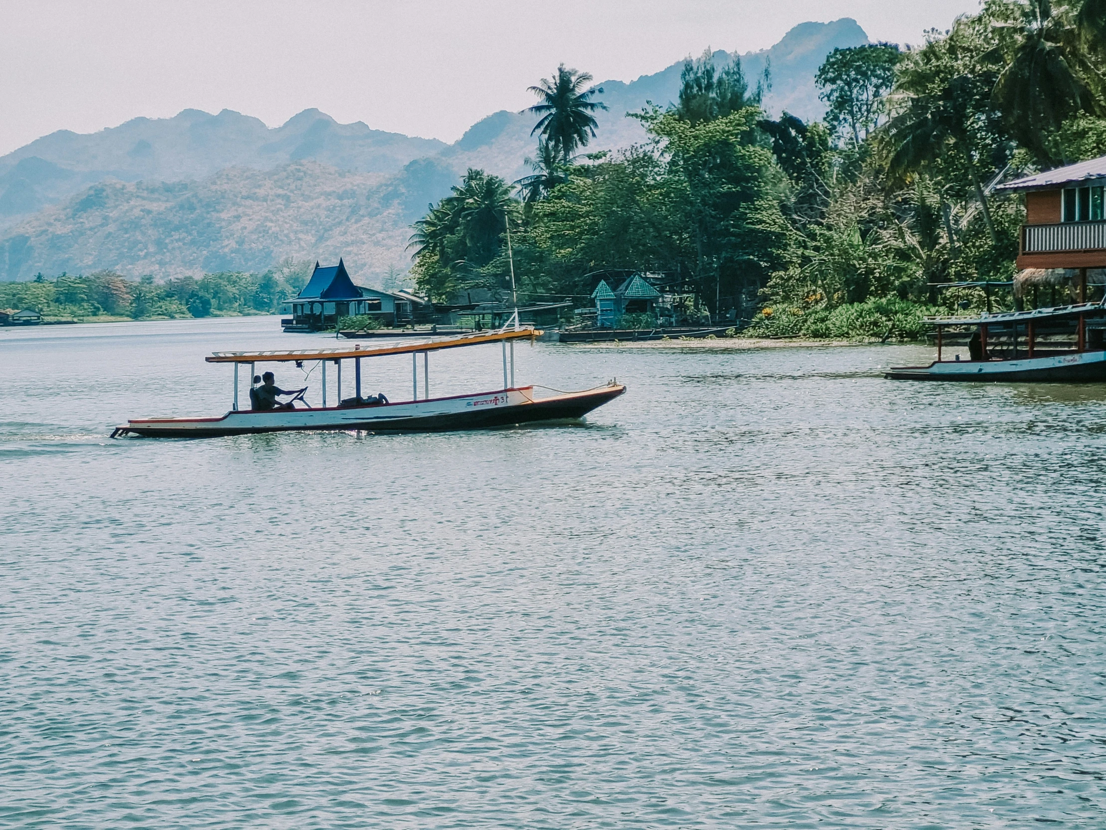 an empty boat on a lake near some mountains