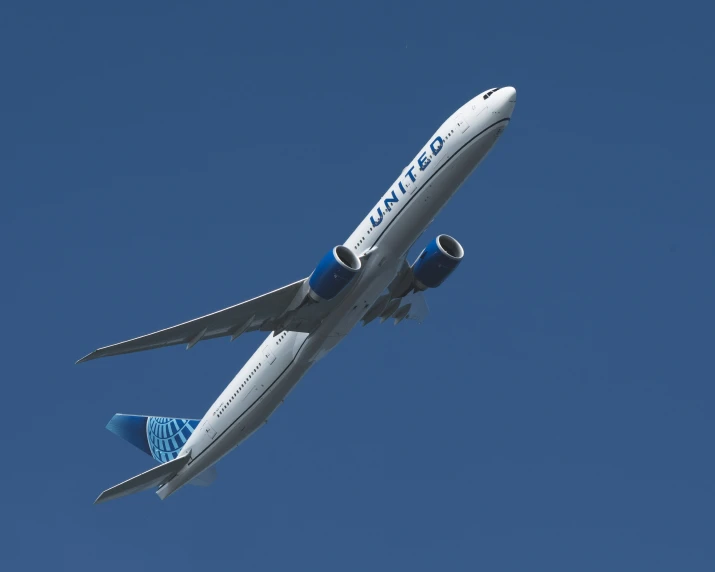 a large airplane flies through the blue sky