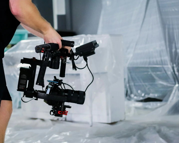 a person standing next to a video camera and some water