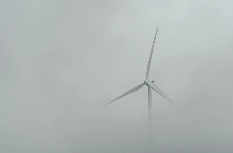 a wind turbine is on a foggy day