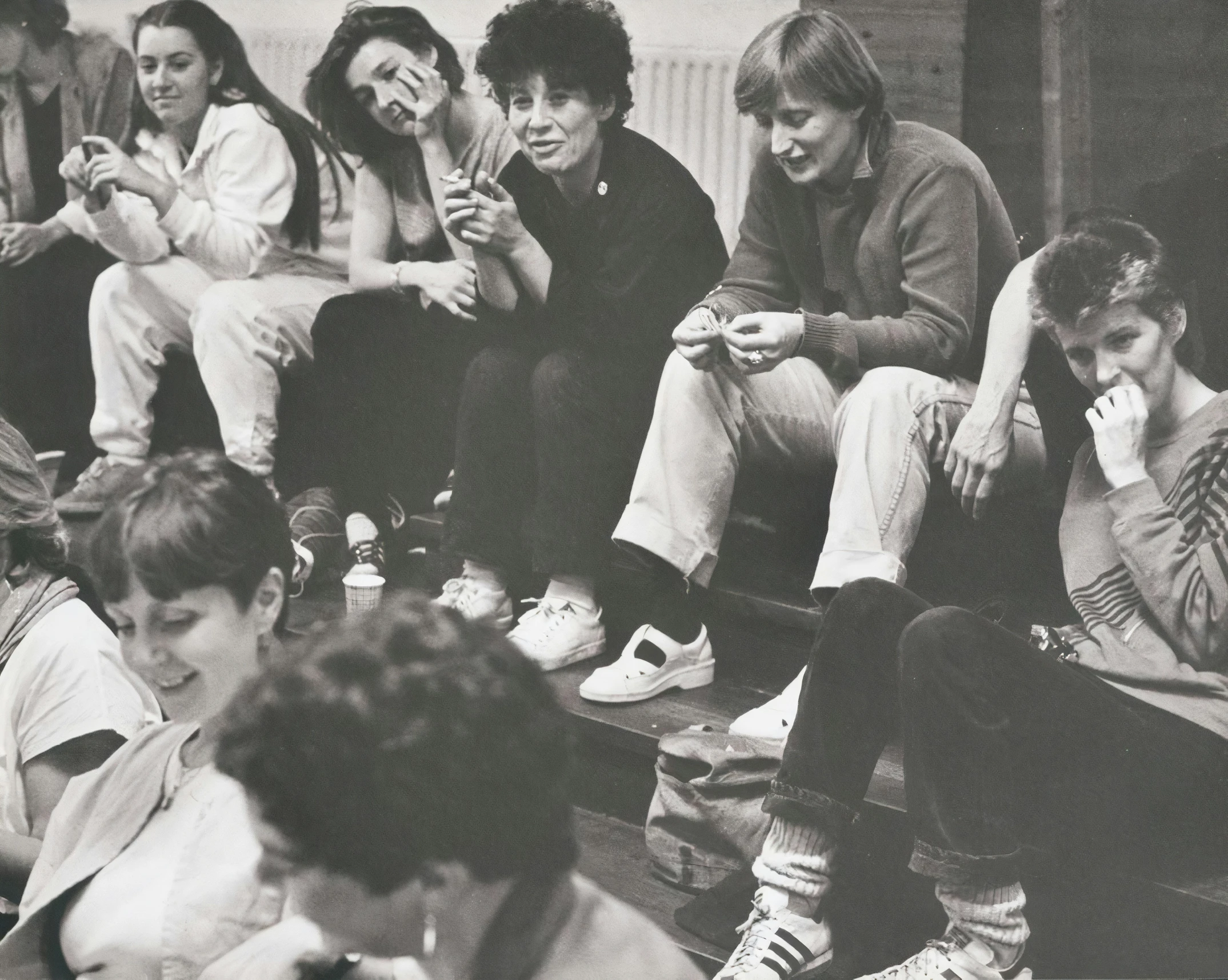 several young people sitting on a coach in the same room