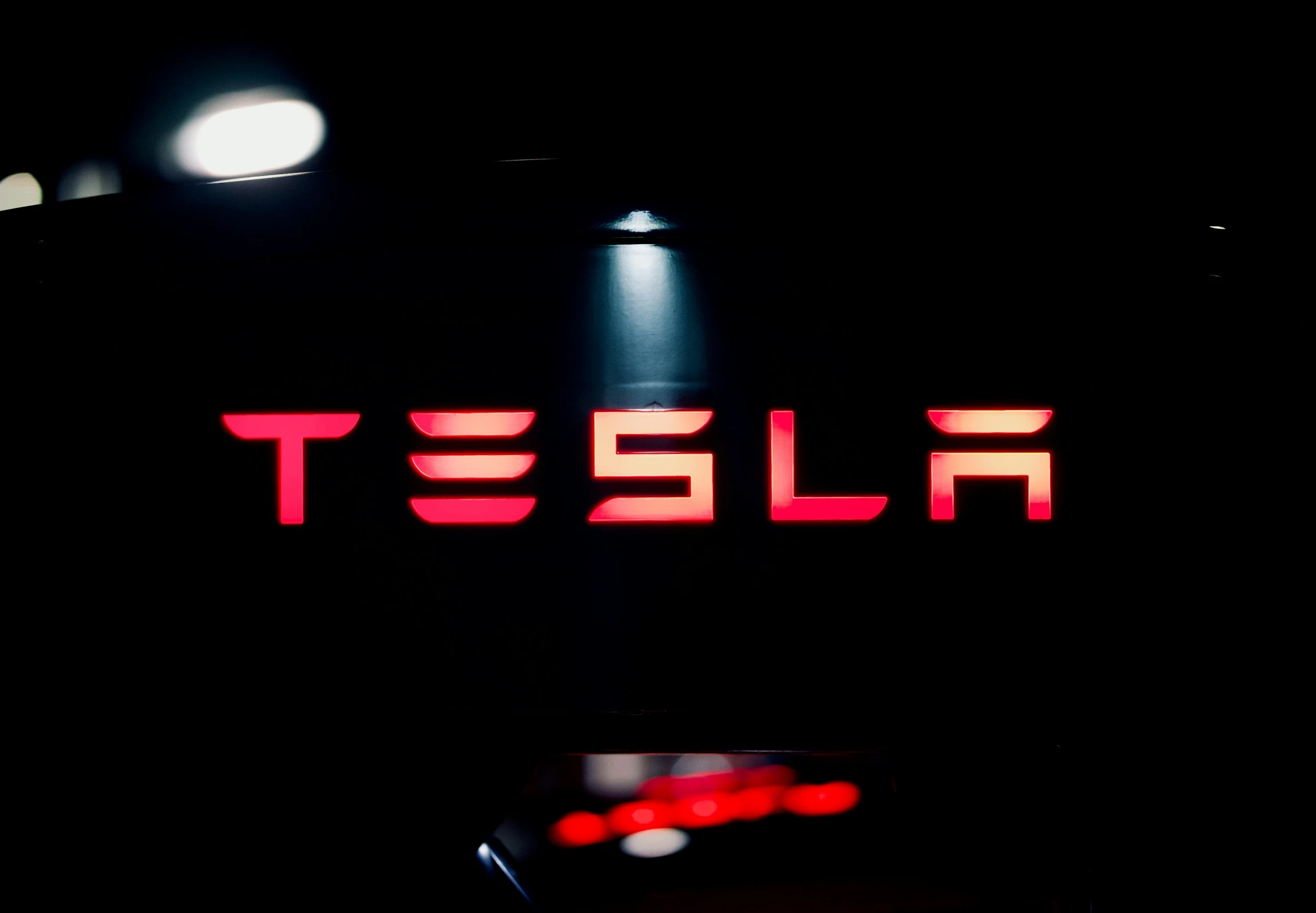 a lit up neon sign that says tesla