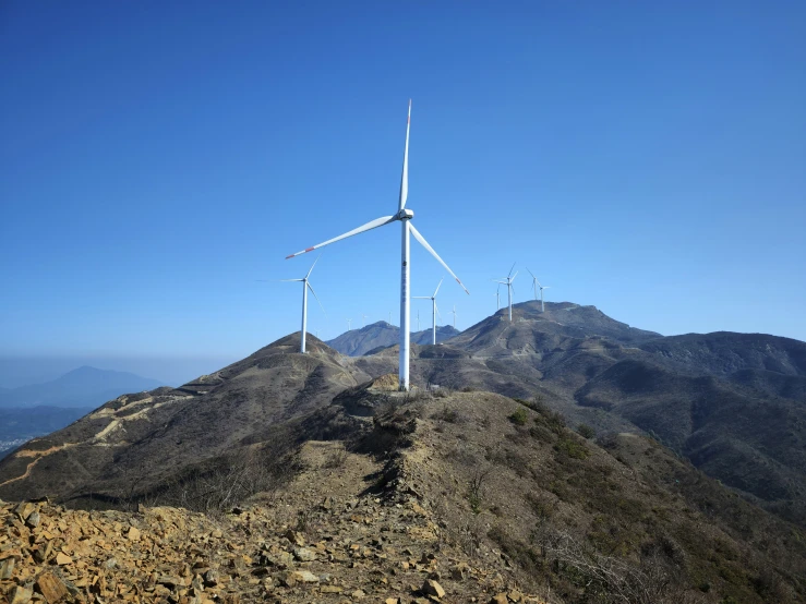 an aerial view of some wind mills on a mountain side