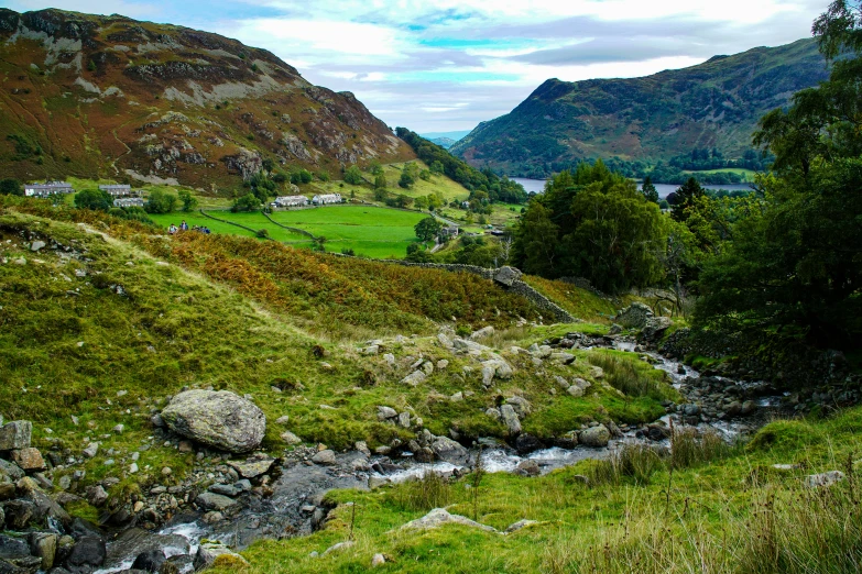 an old, narrow stream runs through a valley next to grassy land