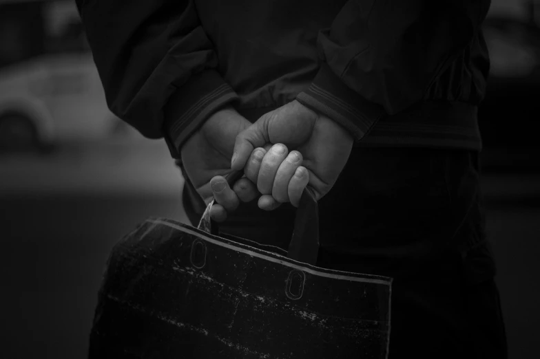 a hand is holding a black suitcase