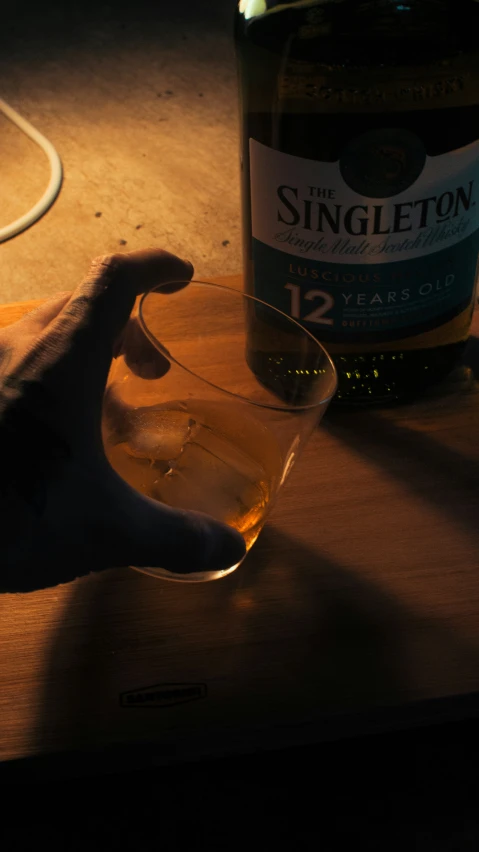 a bottle and glass on a wooden table