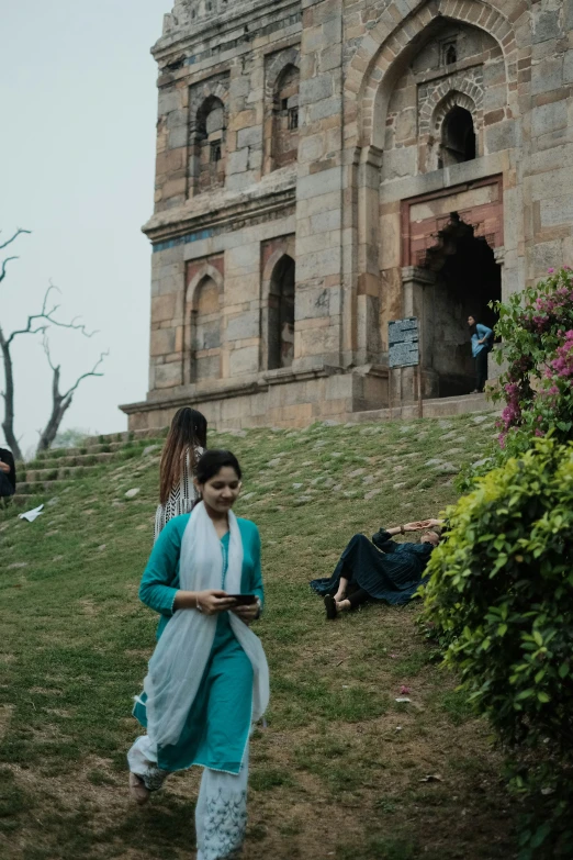 a woman in green is standing on a hill