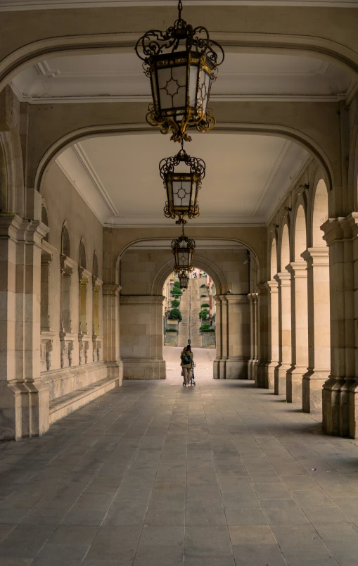 a man rides his bicycle underneath a big hallway