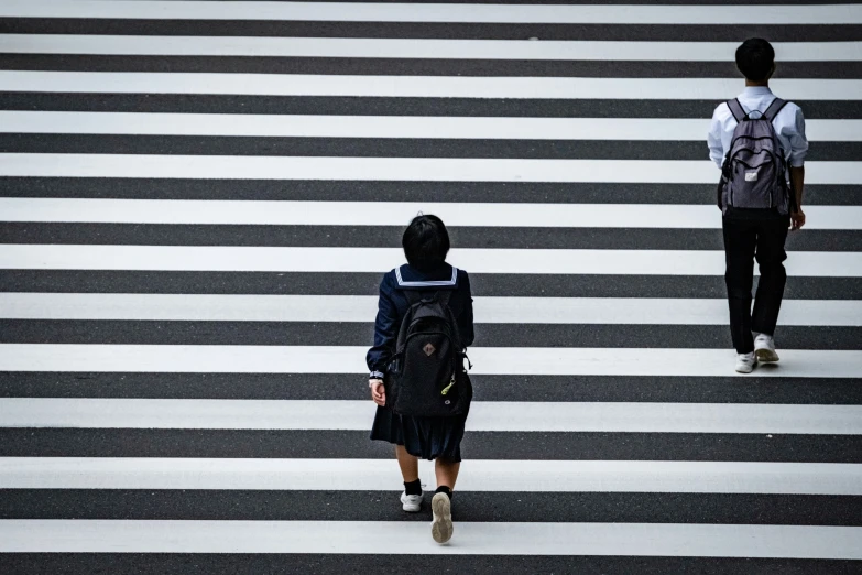 a young woman walking across the street in the middle of crosswalk