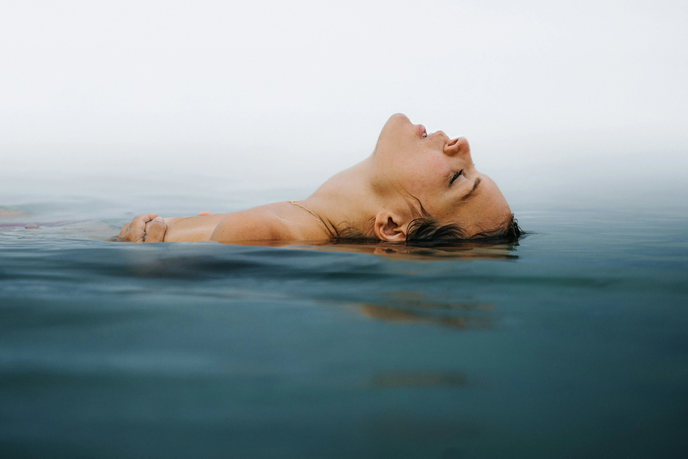 a woman swimming in the ocean during the day