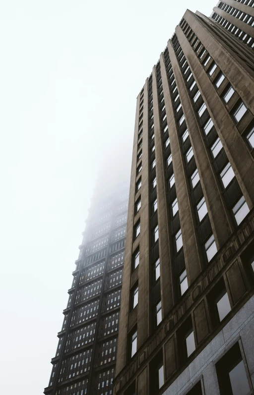 tall buildings with lots of windows and fog on them