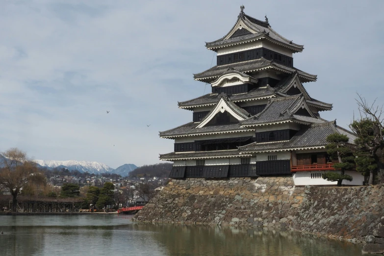 the large tower on top of a mountain next to water