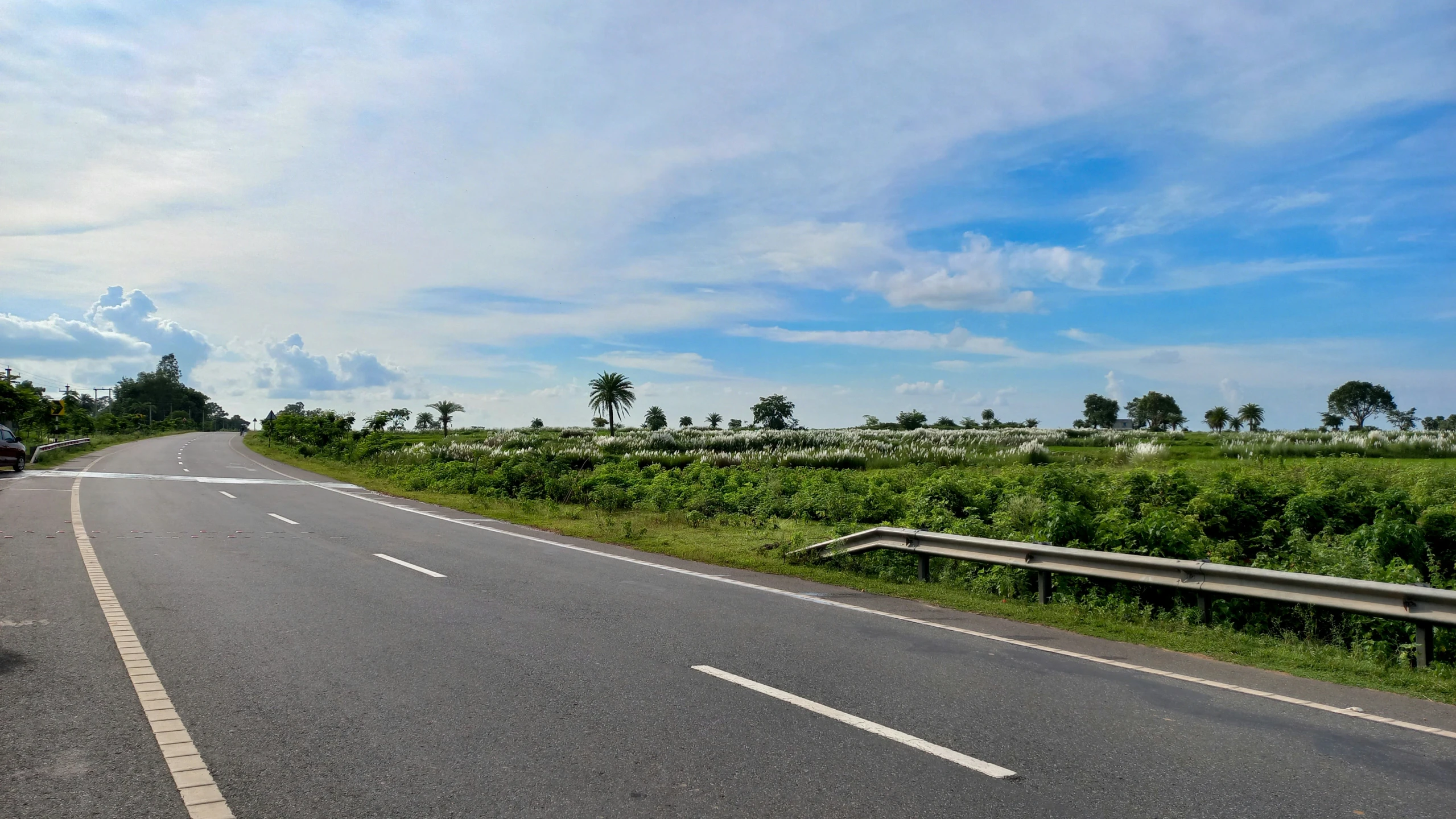 two motorcycle riders ride down the road in front of a truck