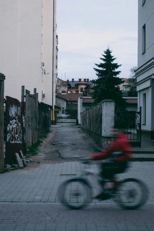 a person riding a bike in an alley