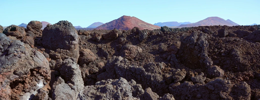 rocky terrain with tall mountains and sky in background