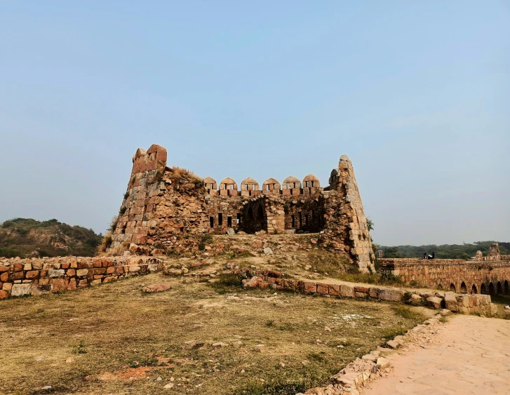 the ruins of an old building sit alone in a field