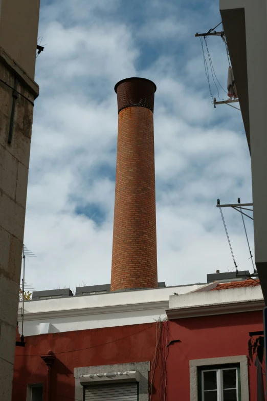 a red brick chimney in the middle of buildings