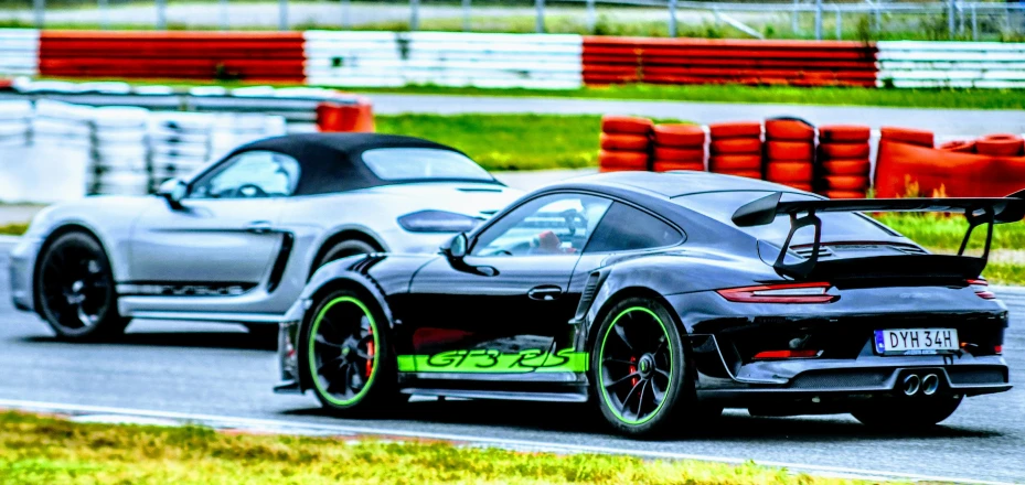 the rear of two racing cars on the race track