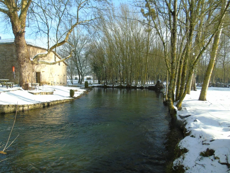 a river with a bridge over it surrounded by snow