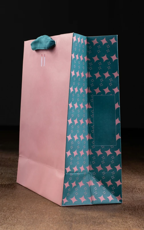 a large pink and blue shopping bag sitting on top of a table