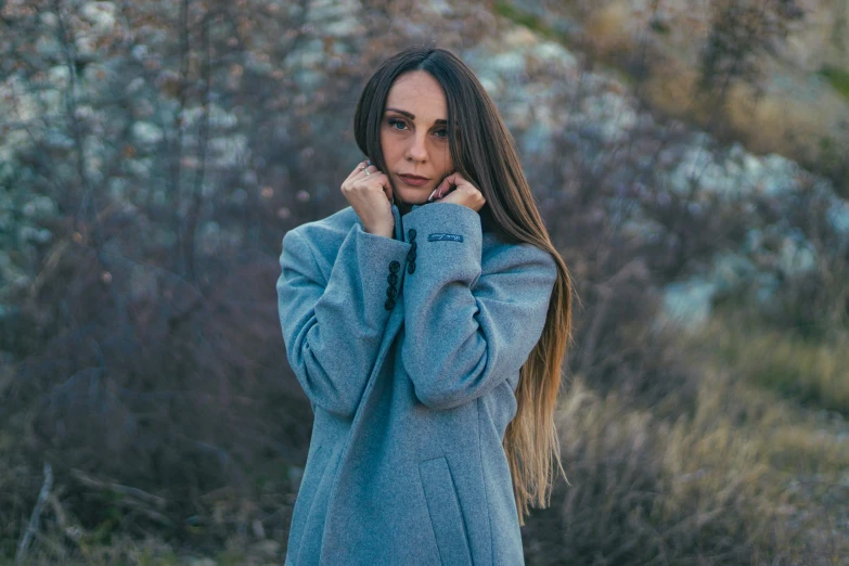 woman in blue coat looking away from camera