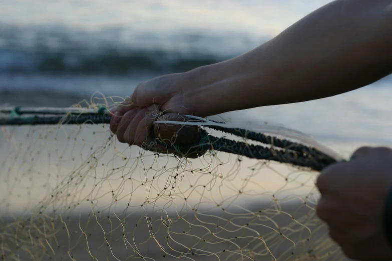 a person holding onto a piece of fishing net