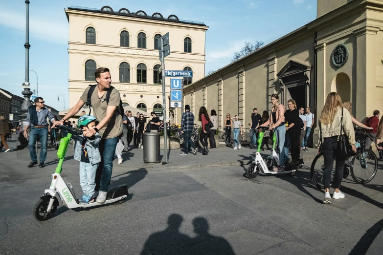 some people are riding scooters on a city street