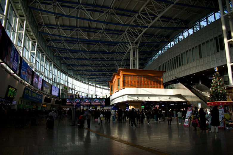 inside of a covered building with people walking and shops