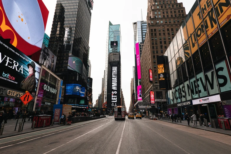 the view down a large city street with buildings on both sides and a taxi going up a hill